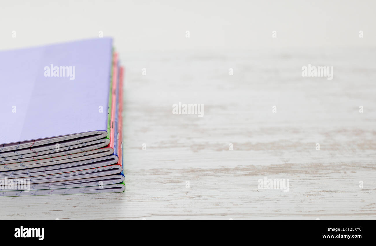 Image of a stack of colorful notebooks on a white wooden table Stock ...
