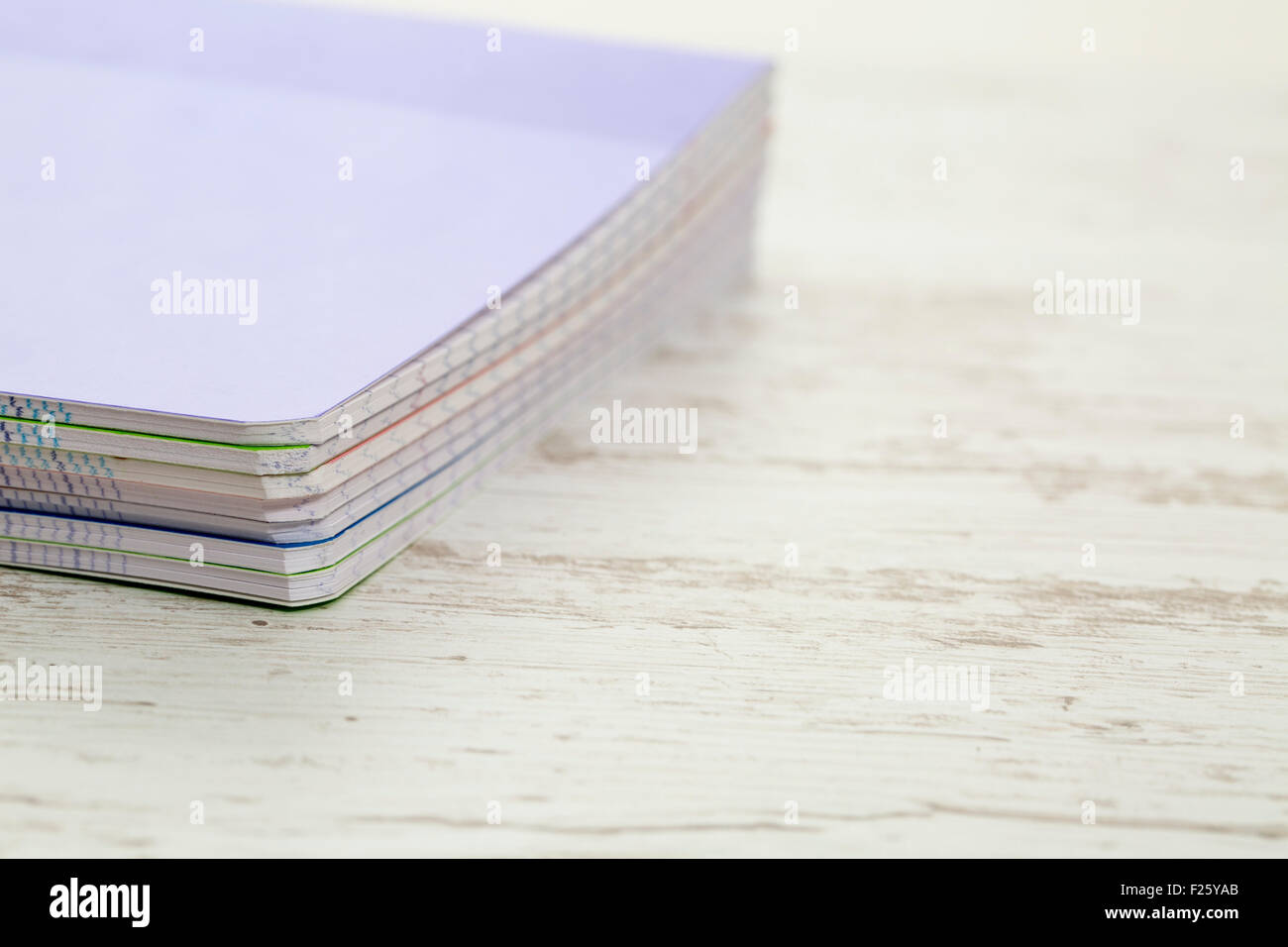 Image of a stack of colorful notebooks on a white wooden table Stock ...