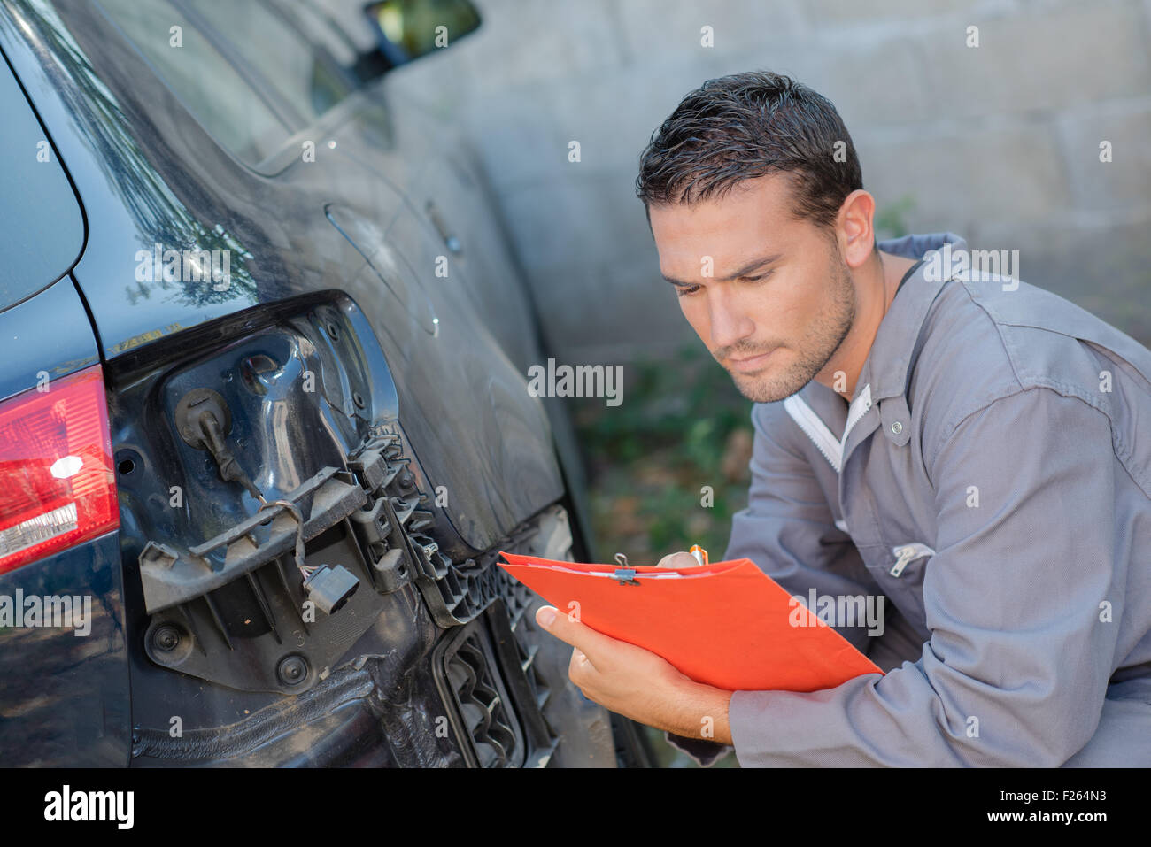 Mechanic taking notes as he assesses a car Stock Photo