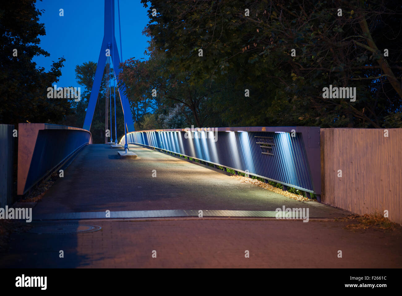 perspective view of footbridge high arch over the city-highway in Berlin at night in the moonlight Stock Photo