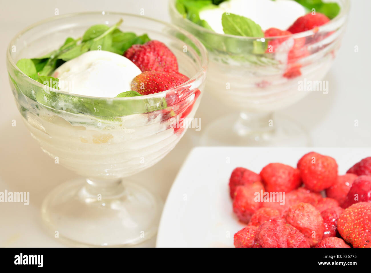 two ice-cream and plate with strawberries Stock Photo