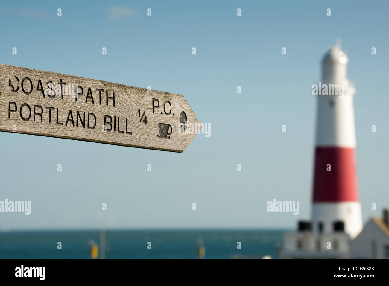 Coastal path fingerpost, pointing at Portland Bill lighthouse, Dorset UK Stock Photo