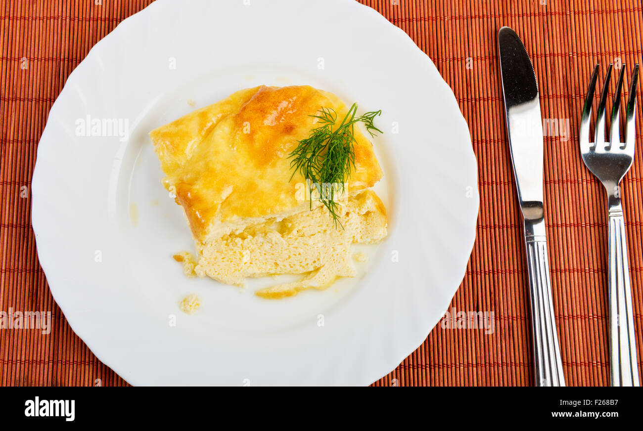 A plate with a Spanish omelet, on a set table Stock Photo