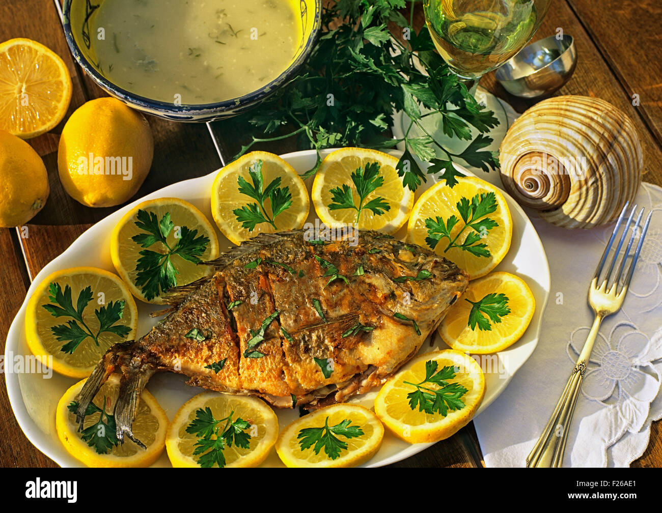 A typical Greek fish dish with Gilthead seabream and lemon sauce Stock