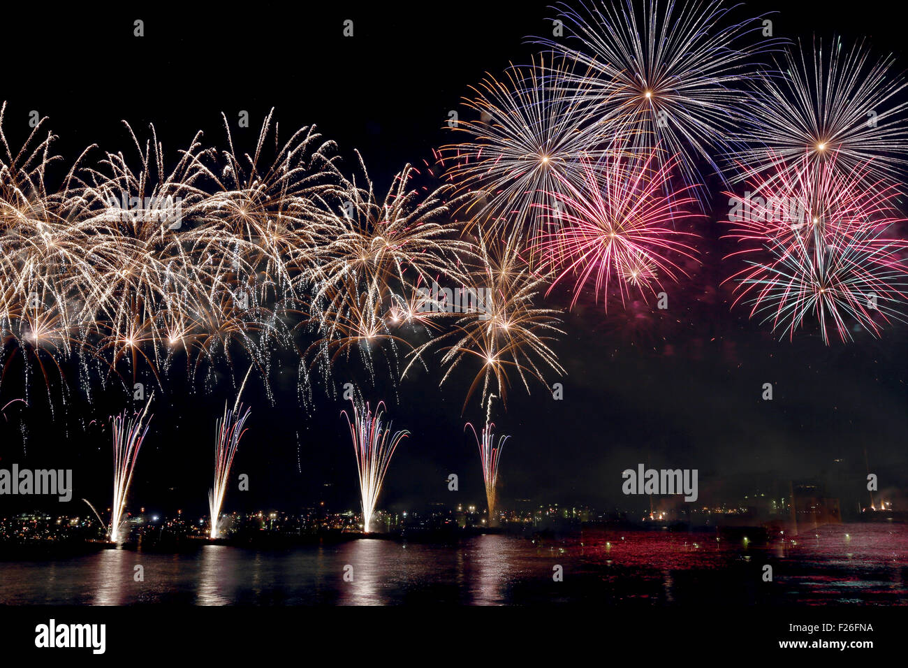 colorful fireworks reflect on sea water Stock Photo