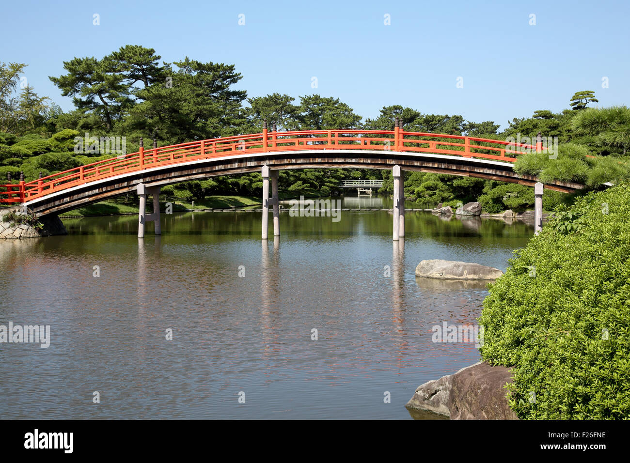 View of Japanese garden with red wooden bridge Stock Photo