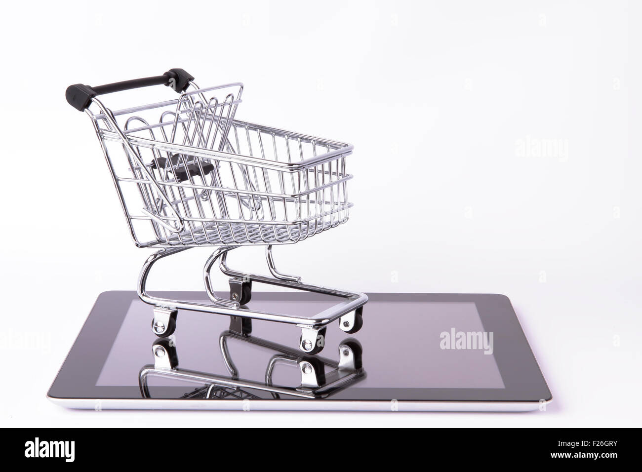 shopping cart on top of a tablet isolated on white background Stock Photo