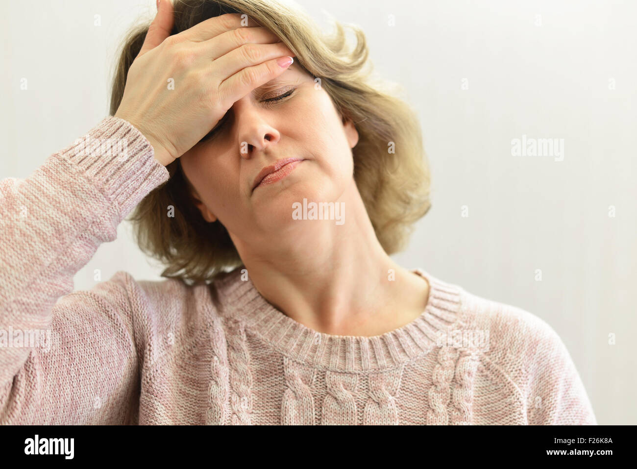 Woman holding hands on  head, depression, pain, migraine Stock Photo