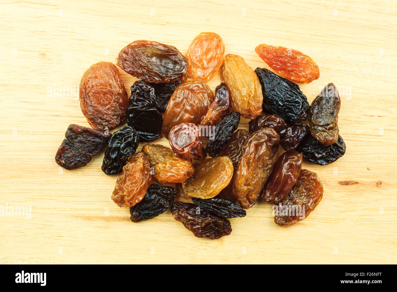 A pile of raisins on brown wooden table Stock Photo - Alamy