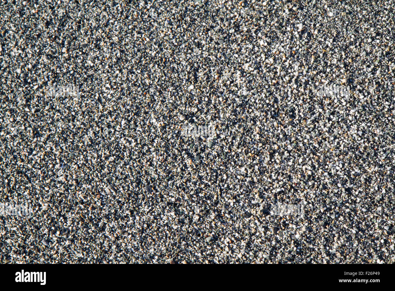 background of wet beach, made up of small gray stones Stock Photo