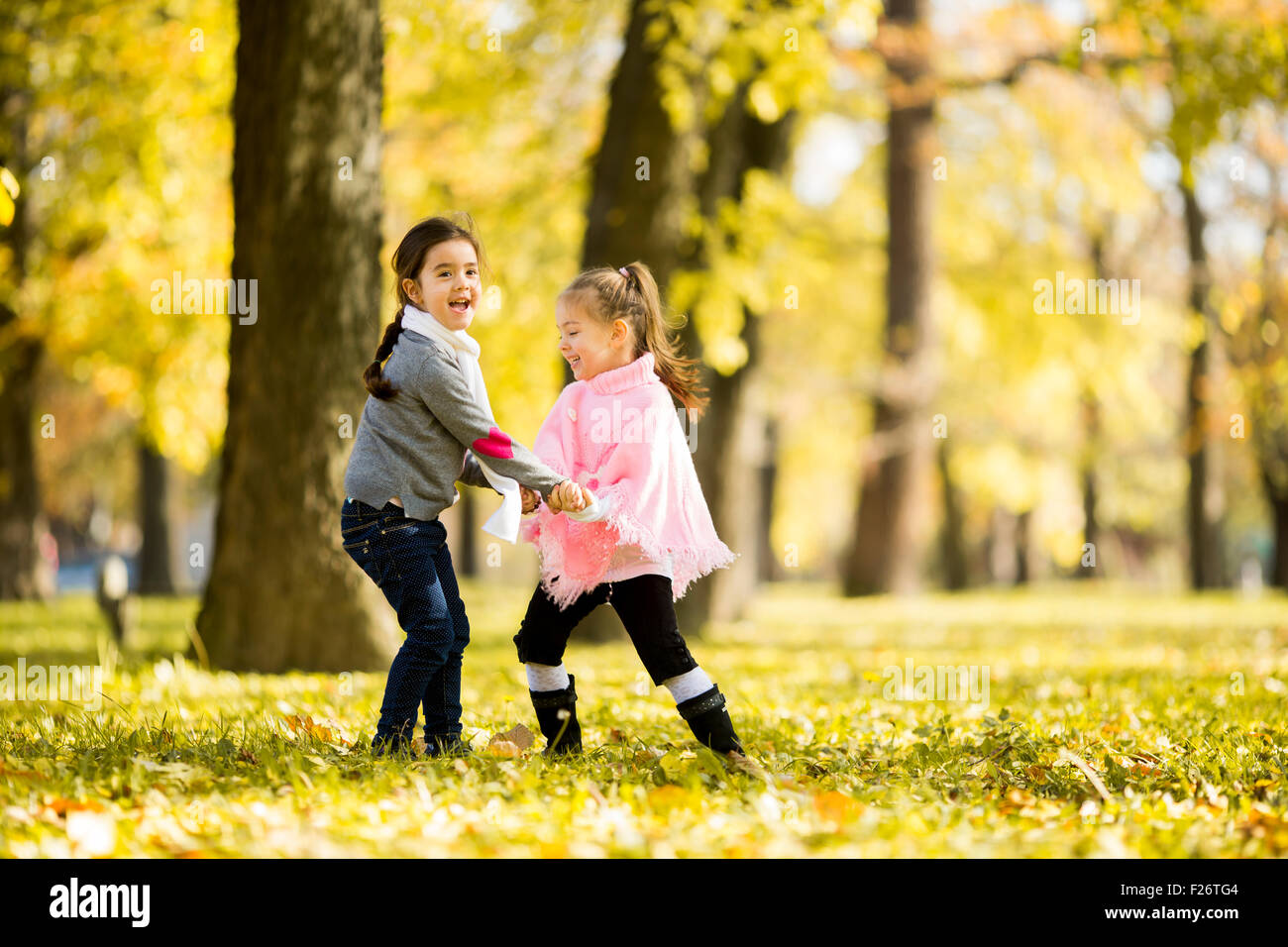 Two little girls at the autumn park Stock Photo - Alamy