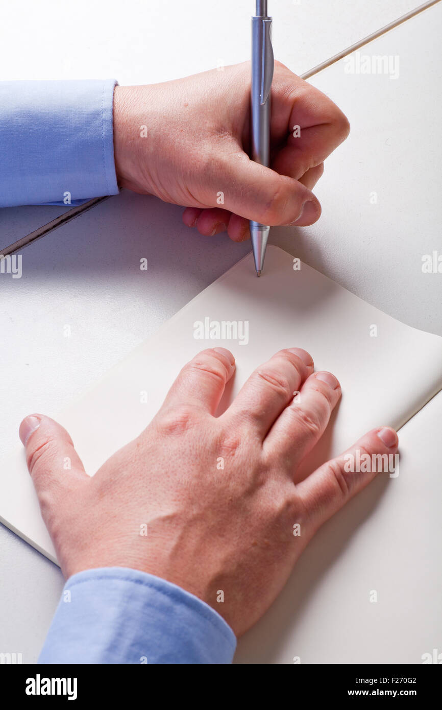Hands of a man writing with a pen on a diaries Stock Photo