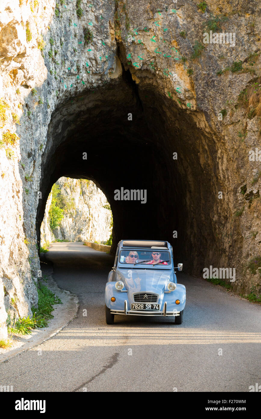 Citroen 2CV car driver / driving climbing through an alpine tunnel and pass (Col De La Chambotte) in the French alps. France Stock Photo