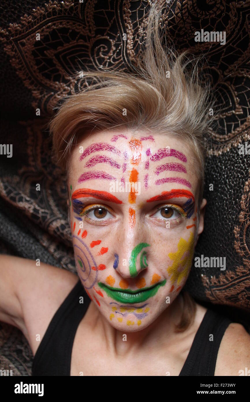 white young woman with painted with colorful signs and symbols on the face Stock Photo