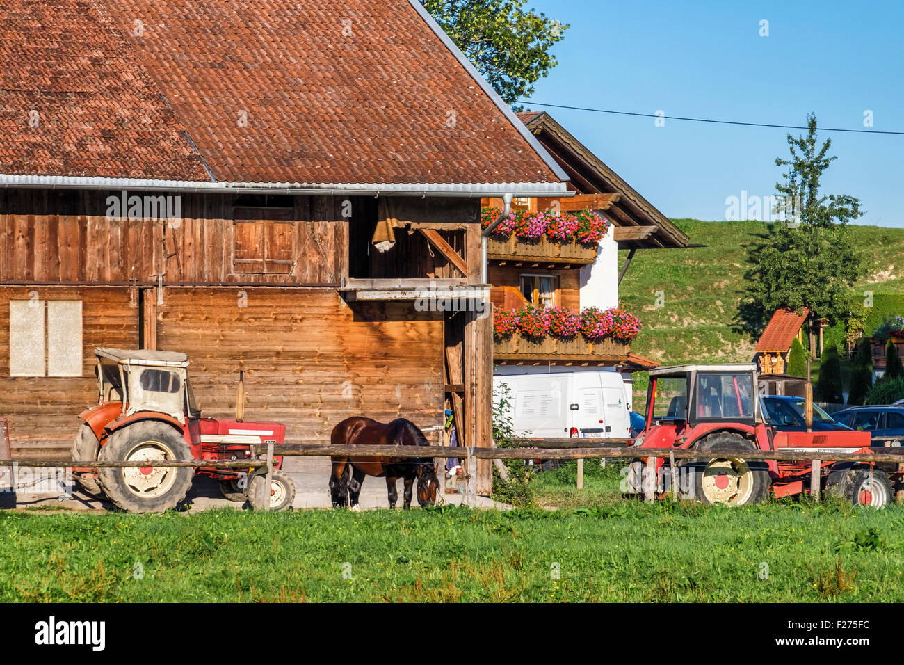 Bavaria, Germany, Farm Yard with wood barn, tractors and horse Stock Photo
