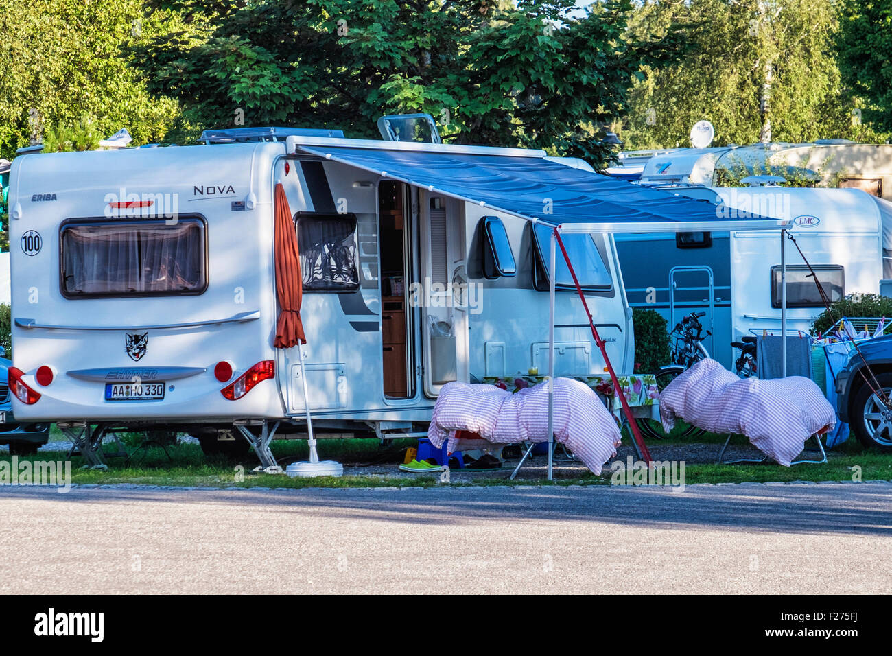 Forggensee lake caravan park with two campers in sleeping bags sleeping outside, Bavaria Germany Stock Photo