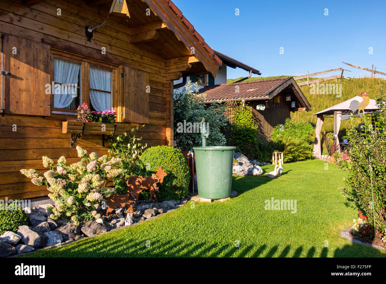 Germany, Bavaria, Typical wooden house exterior and garden ornaments & bird houses Stock Photo