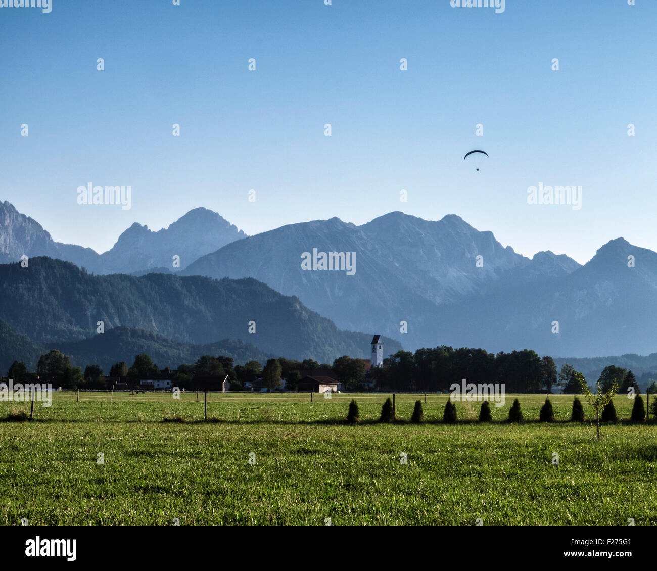Germany, Bavaria. Mountains, fields, Hang-glider and blue sky Stock Photo
