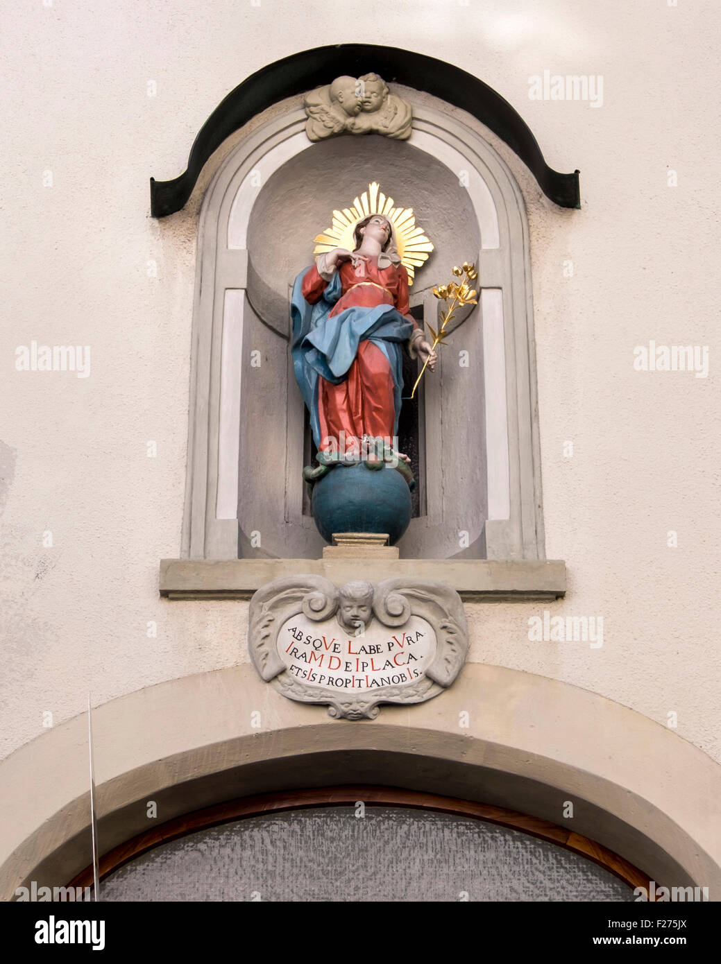 Building detail. Statue of Madonna holding golden lily in alcove. Füssen Town, Ostallgaü, Bavaria, Germany Stock Photo