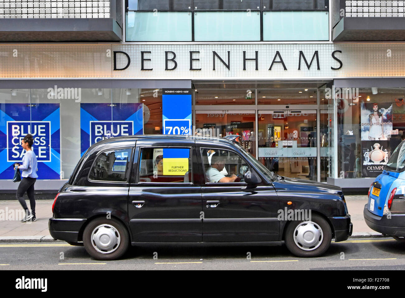 London taxi driver in London black cab in Oxford Street waiting outside entrance to Debenhams department store West End London England UK shopping Stock Photo