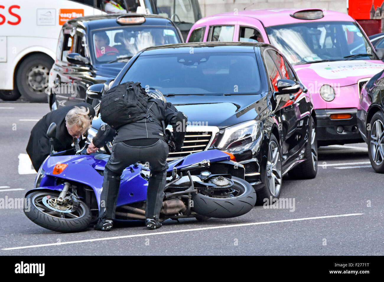 Road accident car and motorbike collision at give-way road junction  no apparent injuries some vehicle damage London England UK Stock Photo