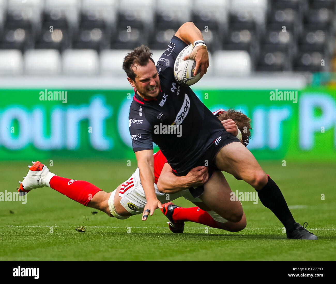 Swansea, Wales. 13th Sep, 2015. Guinness Pro12. Ospreys versus Munster Rugby. Ospreys Dan Evans gets tackled by Munster's Dave Foley. © Action Plus Sports/Alamy Live News Stock Photo
