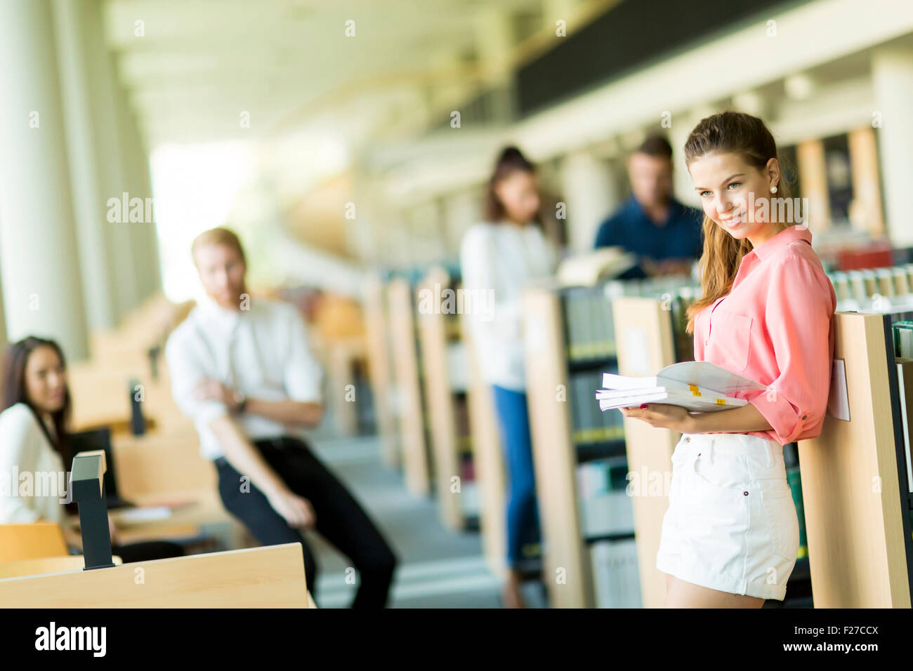 Young woman in the library Stock Photo - Alamy