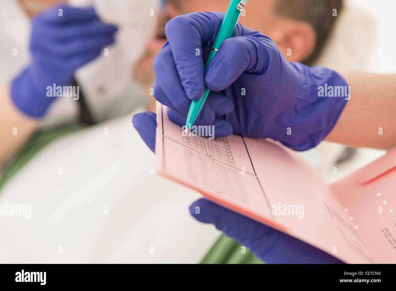 Dental assistant writing on index card, Munich, Bavaria, Germany Stock Photo