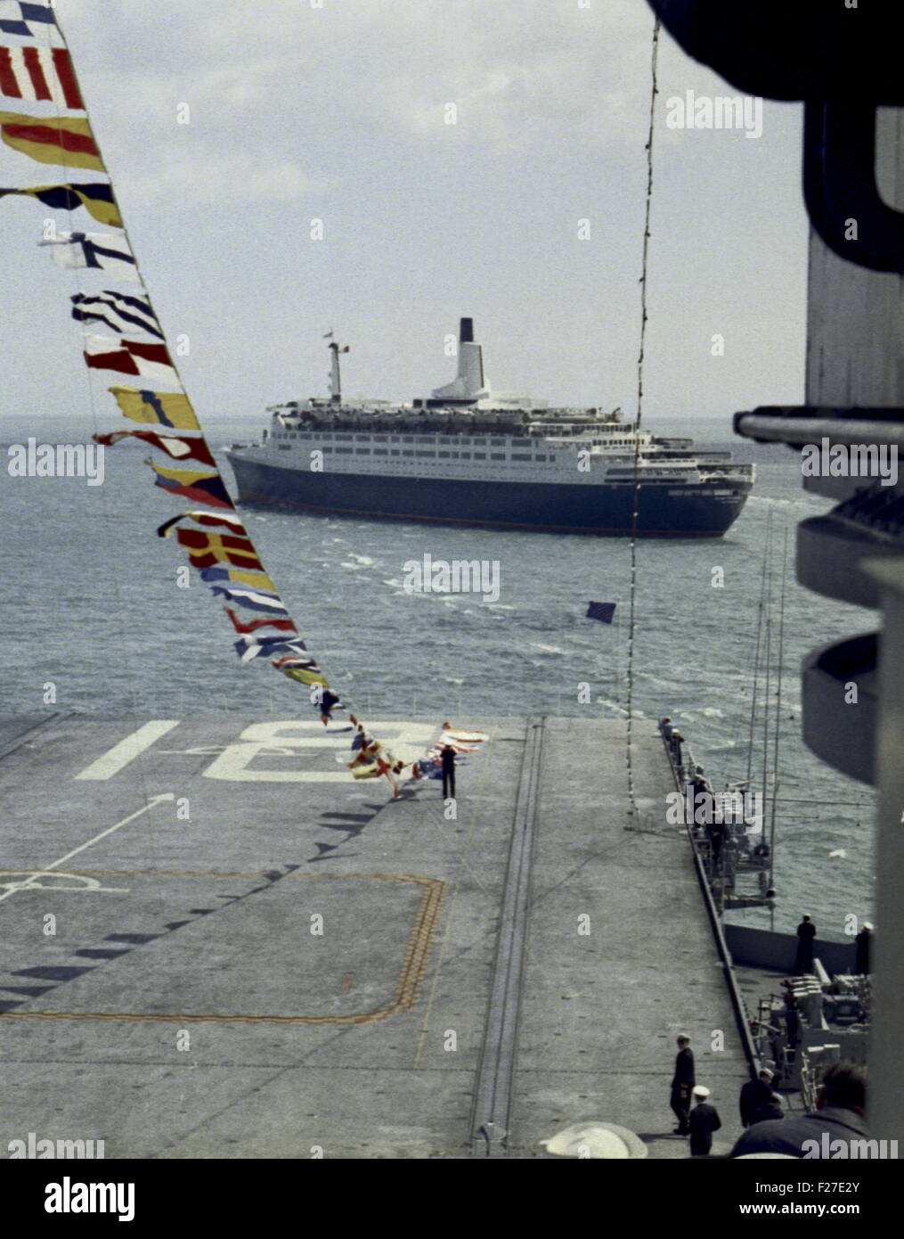 AJAXNETPHOTO - 16TH MAY 1969. SPITHEAD, ENGLAND.  - CUNARD'S PASSENGER LINER QE2 STEALS THE SHOW - PICTURED OFF SPITHEAD FROM THE DECK OF THE USS WASP, DURING THE ROYAL REVIEW OF 61 WARSHIPS OF TWELVE N.A.T.O. (NORTH ATLANTIC TREATY ORGANISATION) COUNTRIES BY H.M. QUEEN ELIZABETH II EMBARKED ON THE ROYAL YACHT BRITANNIA.  PHOTO:JONATHAN EASTLAND/AJAX REF:NATO REV 69 Stock Photo