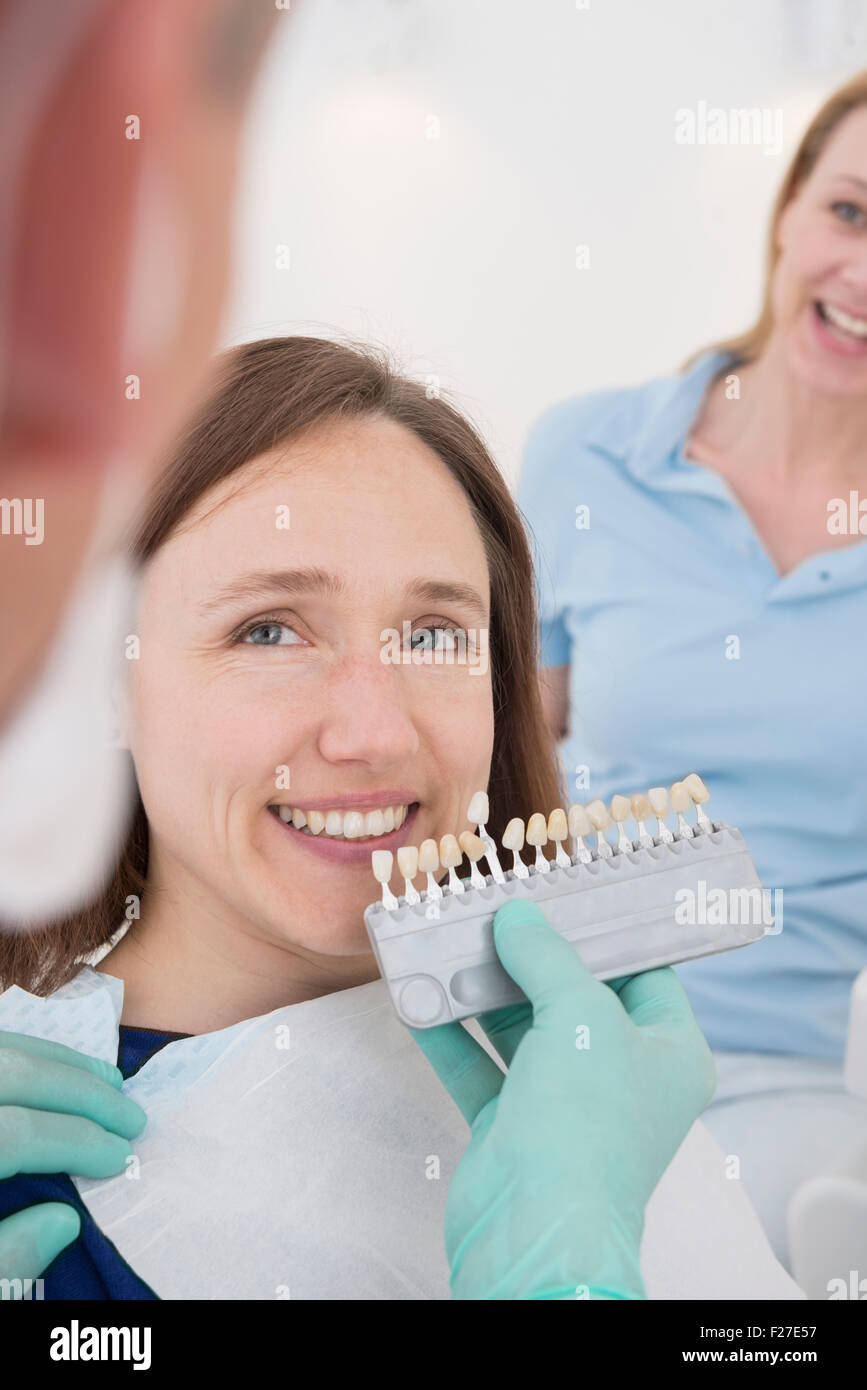 Dentist and patient selecting teeth colour, Munich, Bavaria, Germany