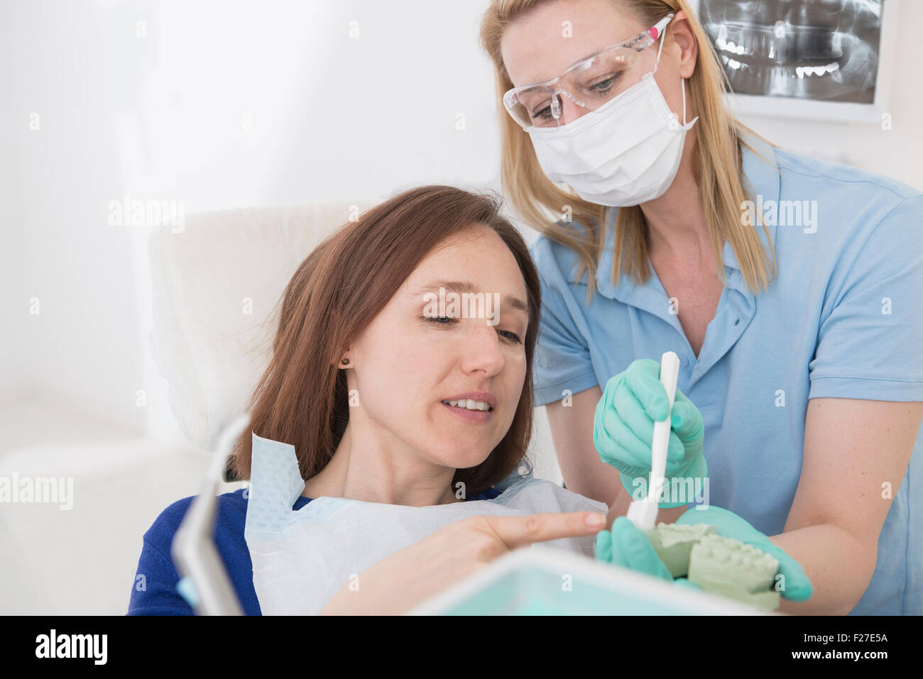 Dental assistant explaining a patient how to brush teeth, Munich, Bavaria, Germany Stock Photo