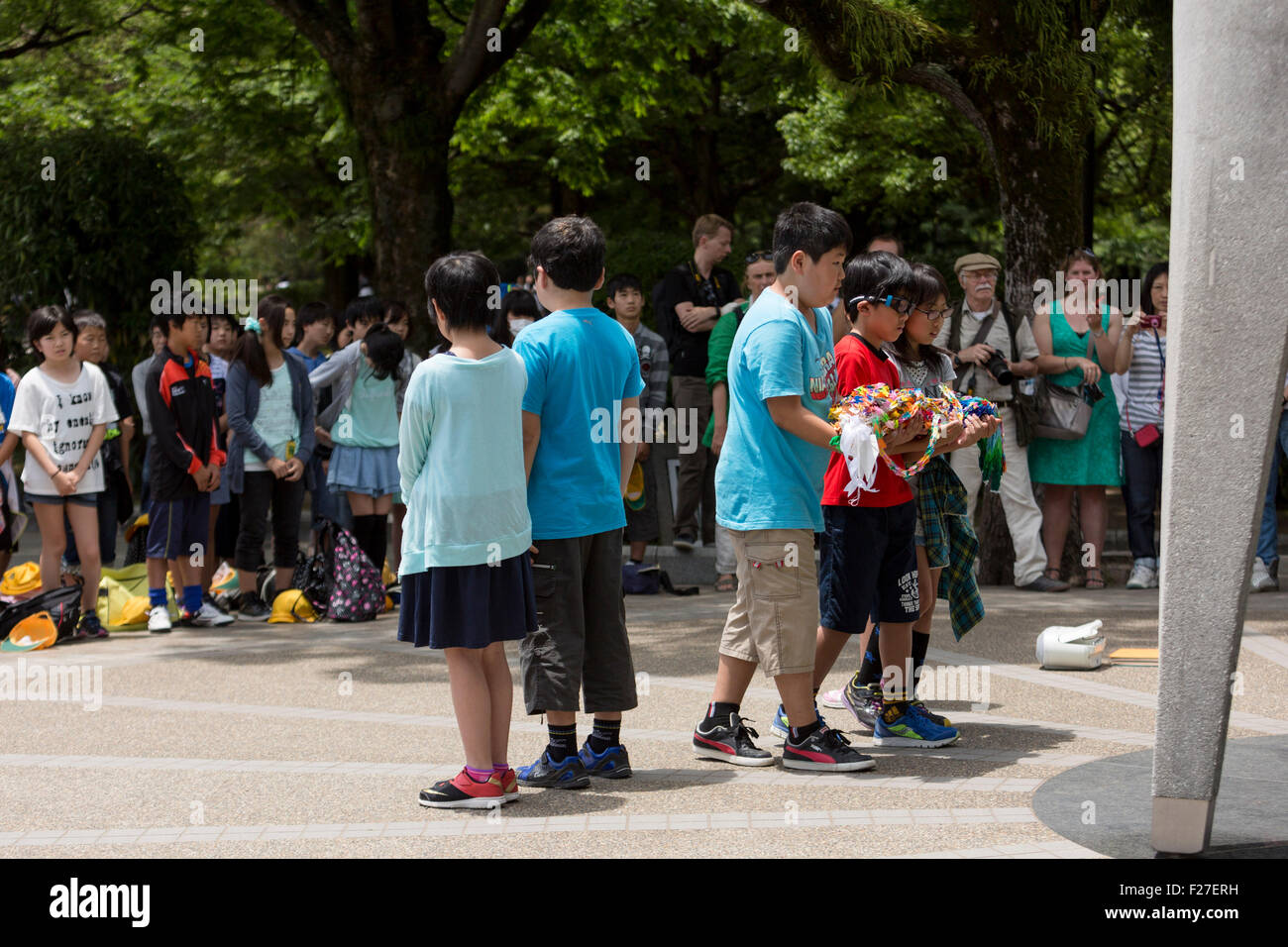 Students gathering at the Children's Peace Monument to honour the memory of atomic bombing victims. Hiroshima Peace Memorial, Hi Stock Photo