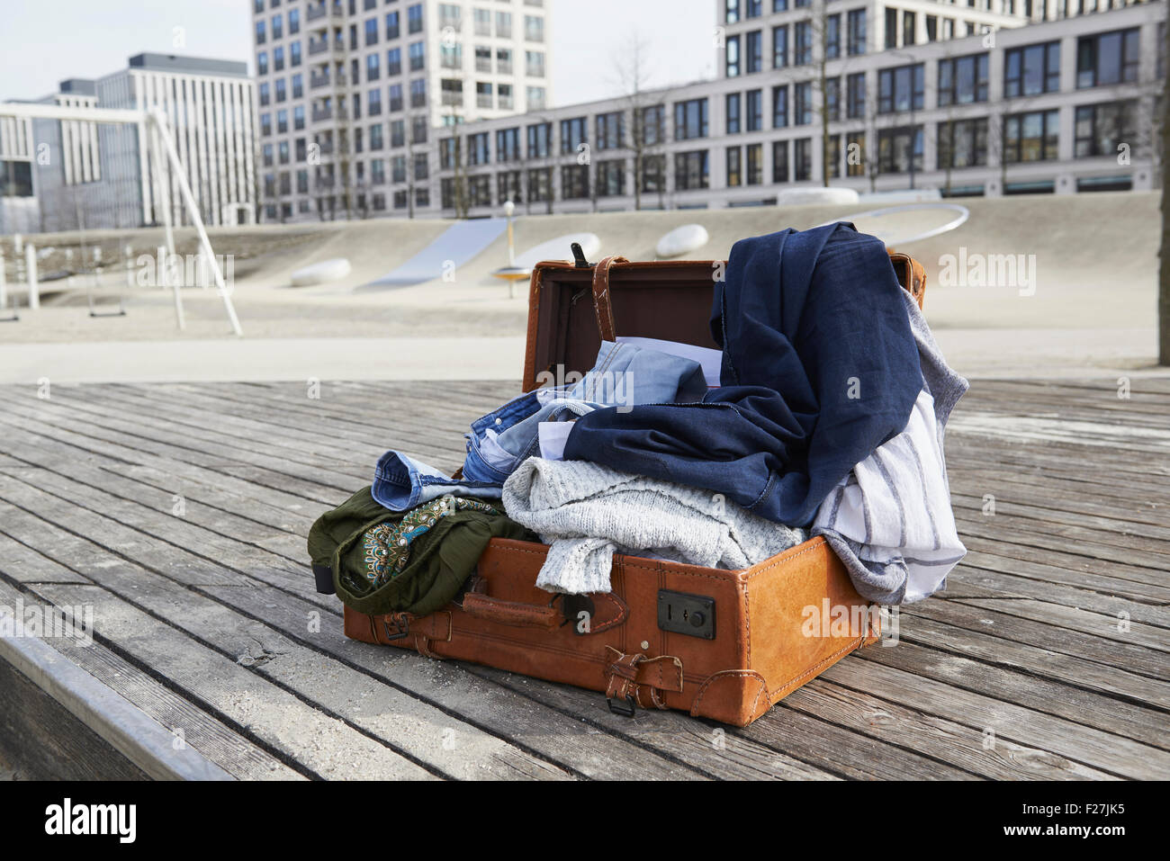https://c8.alamy.com/comp/F27JK5/open-suitcase-full-of-clothing-on-floorboard-in-playground-munich-F27JK5.jpg