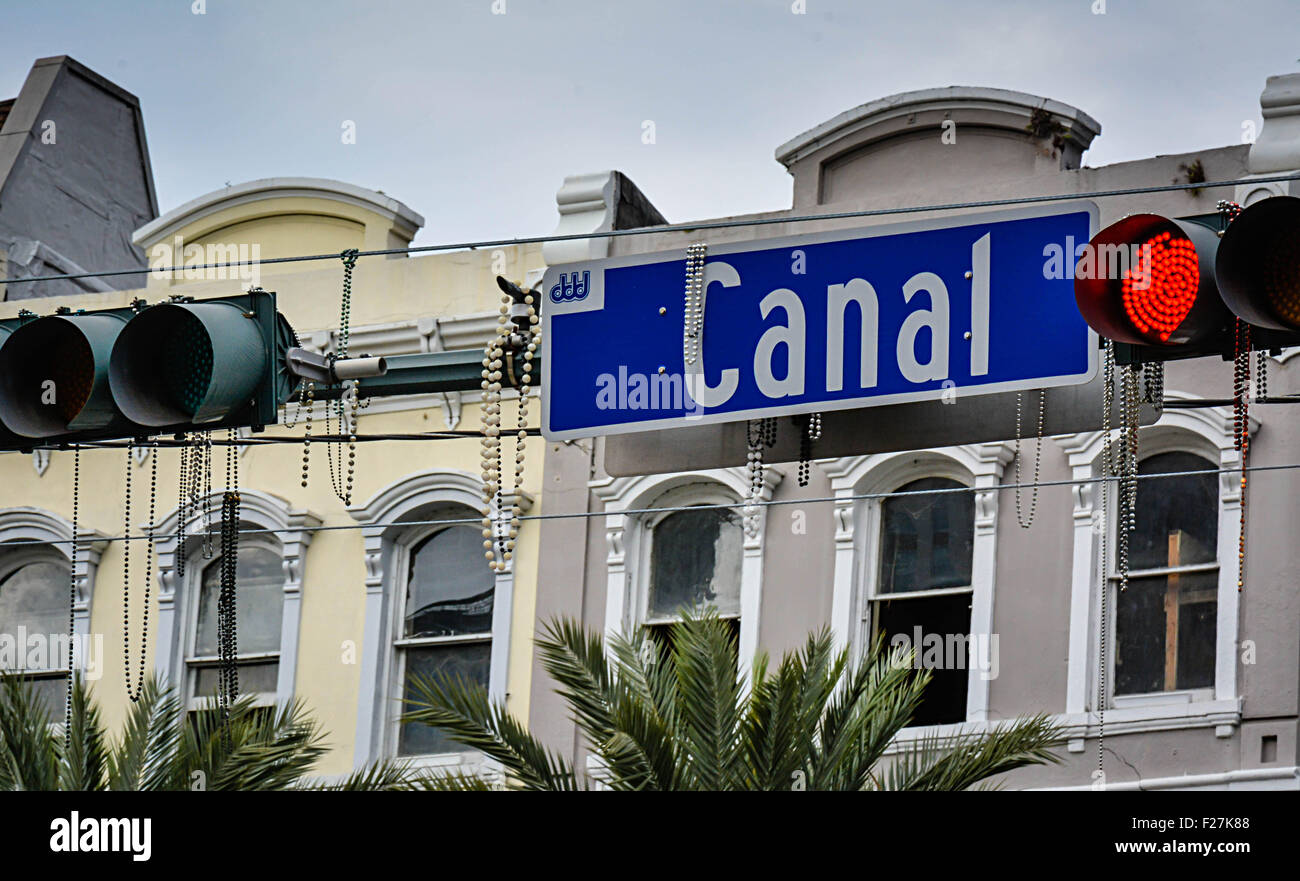 Madri Gras beads hang from Canal Street overhead street sign with traffic lights and classic New Orleans architecture Stock Photo
