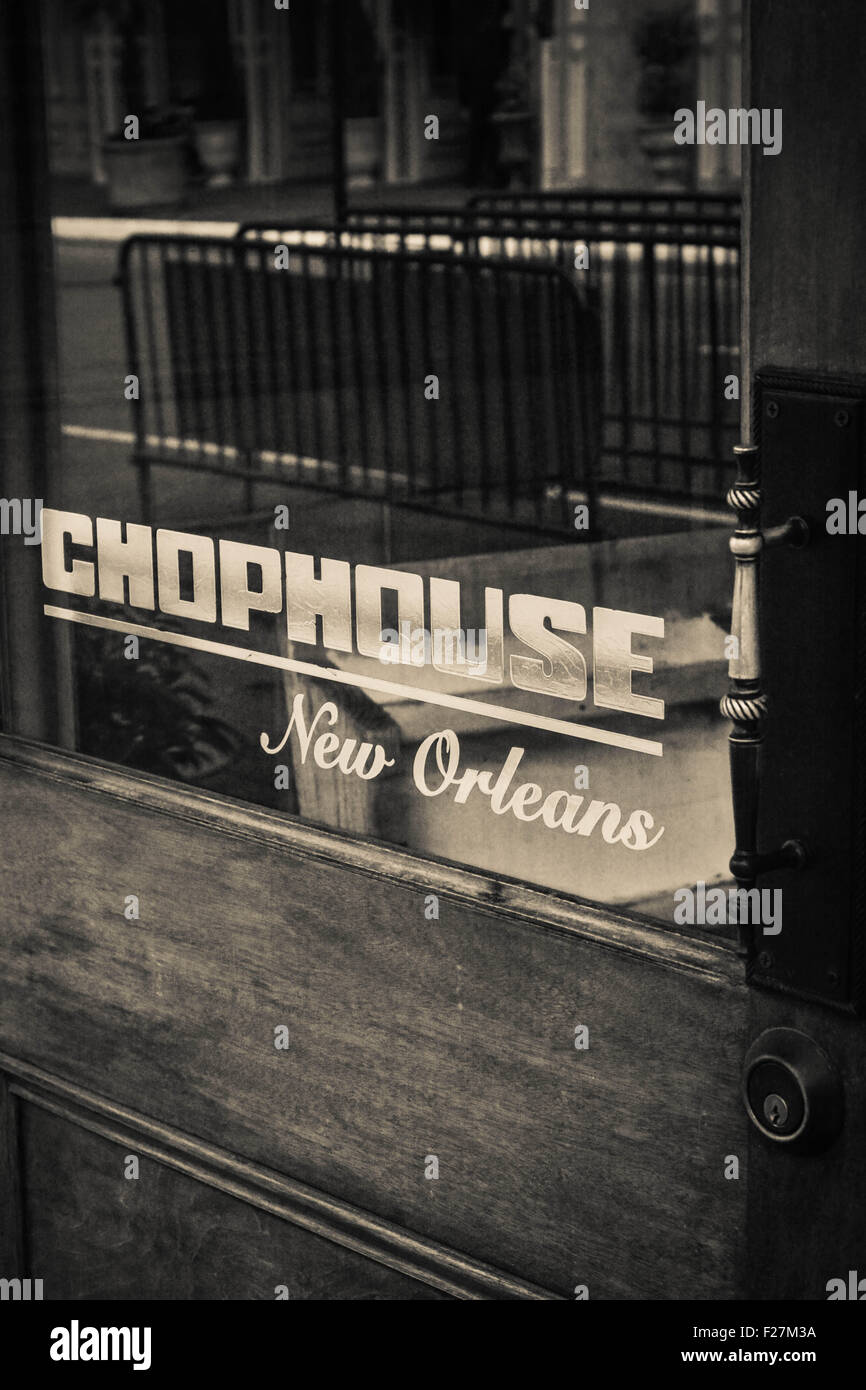 Black & white image of wooden and glass entrance door to the Chophouse Restaurant on Magazine Street in New Orleans, LA Stock Photo