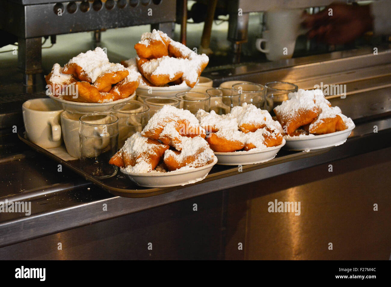 Plates piled high with with powdered sugar on trays at the