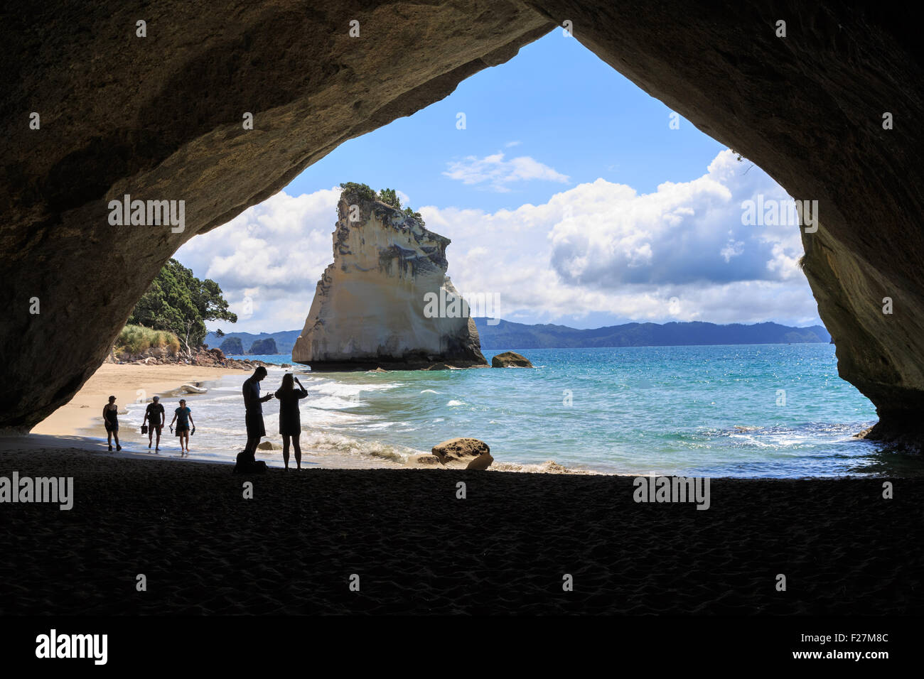 Silhouettes in Cathedral cove, a hole in a rock on the peninsula Coromandel, New Zealand Stock Photo