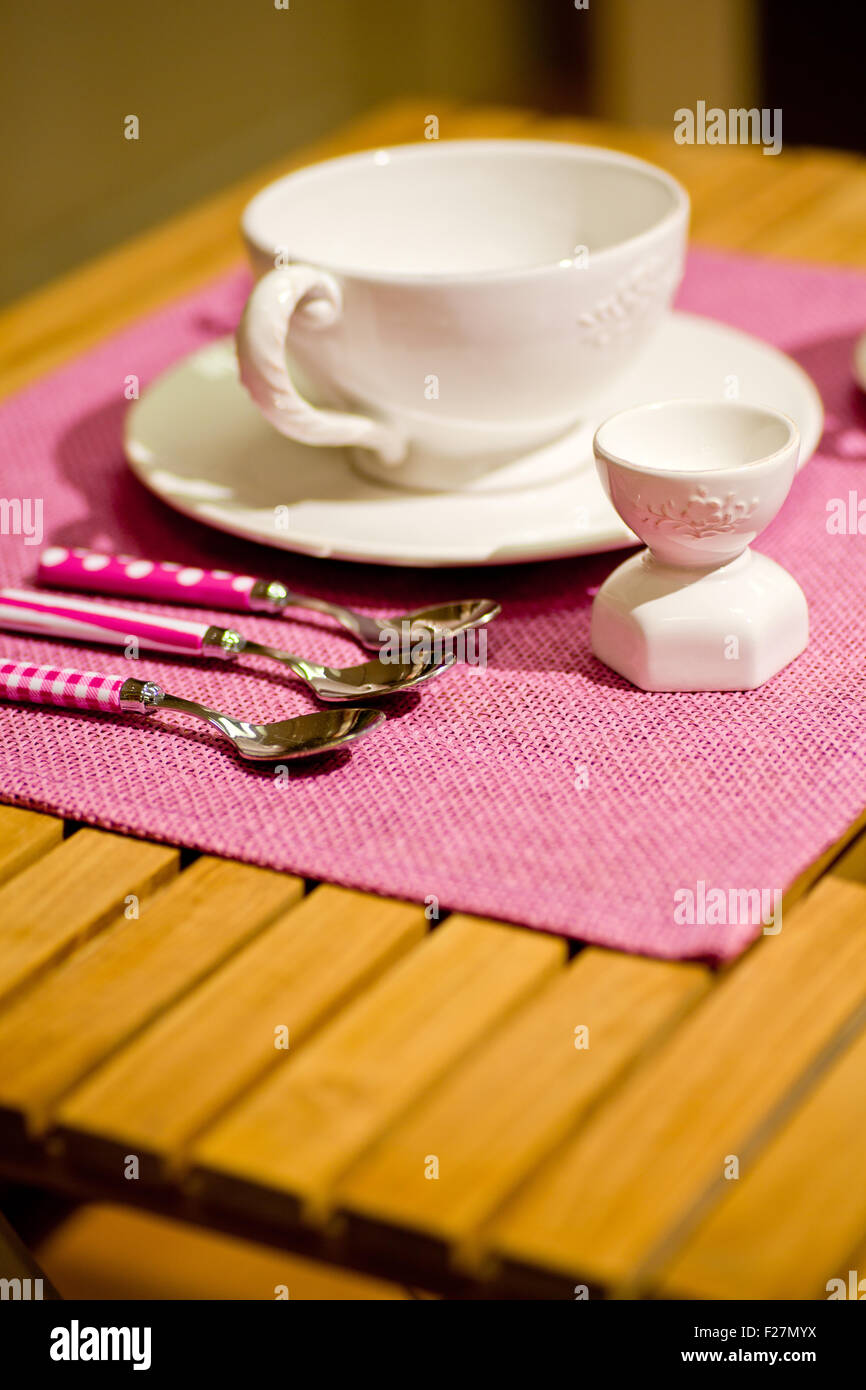 Spoons, breakfast cup and egg cup on a table Stock Photo Alamy