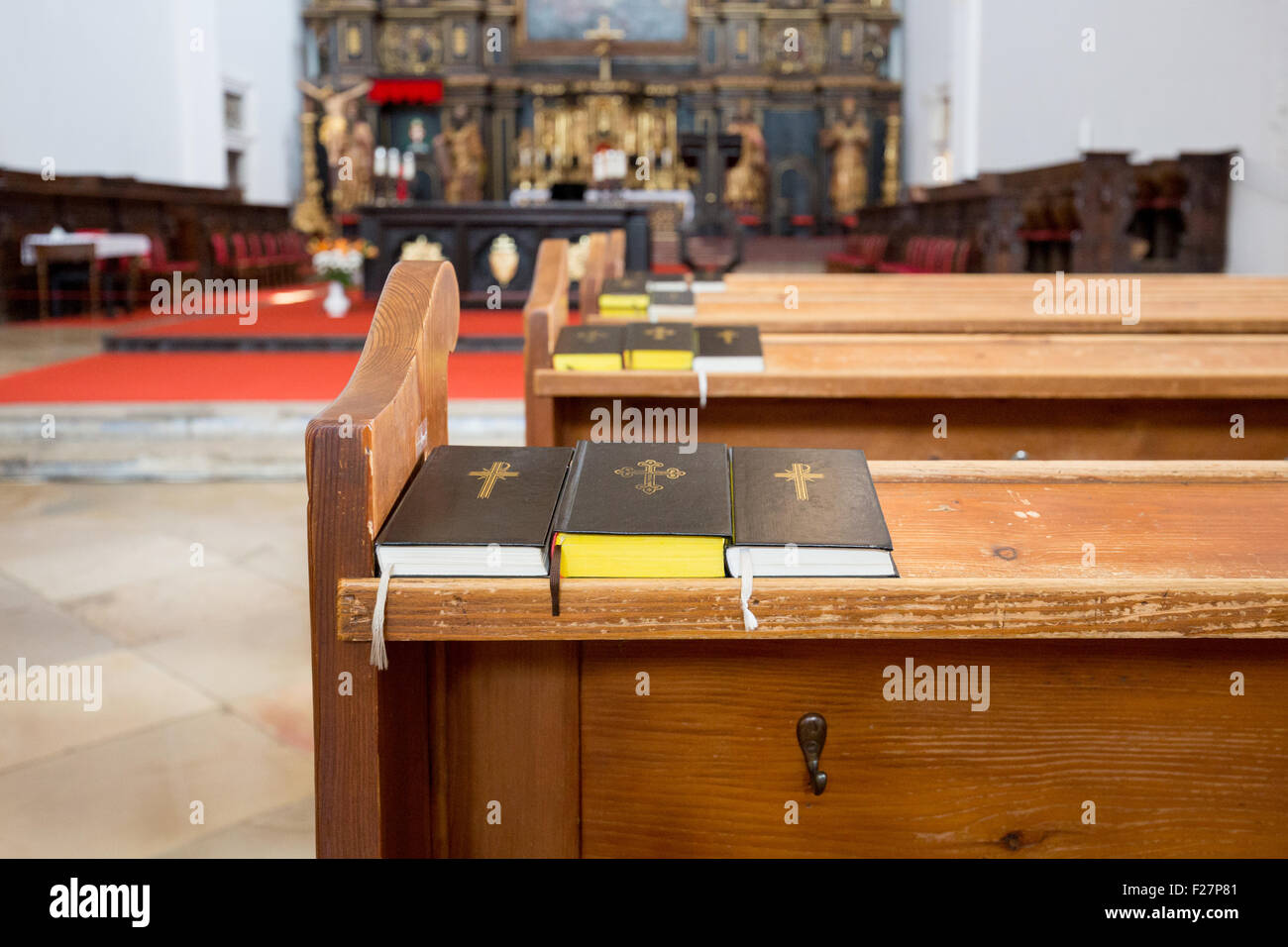 Three prayer books on a wooden bench in St. John the Baptist Cathedral, Trnava Stock Photo