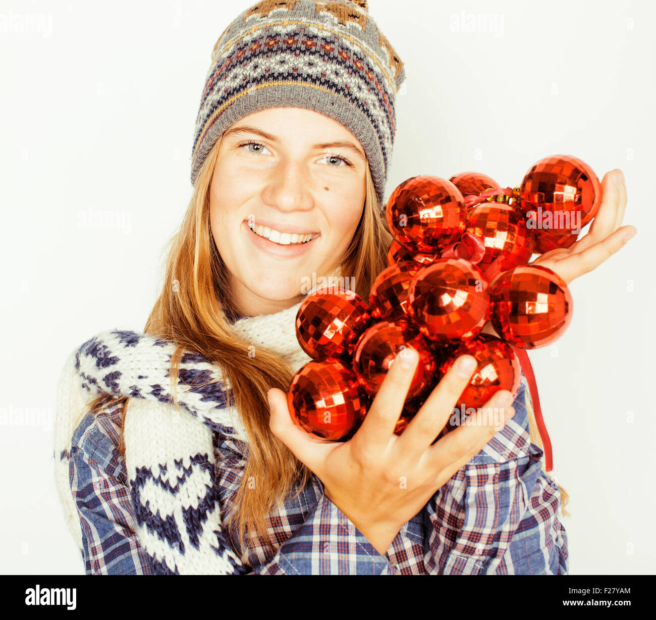 young pretty blond teenage girl in winter hat and scarf on white