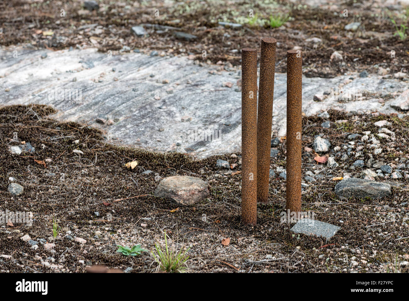 Three rusty spikes in a large rock Stock Photo Alamy