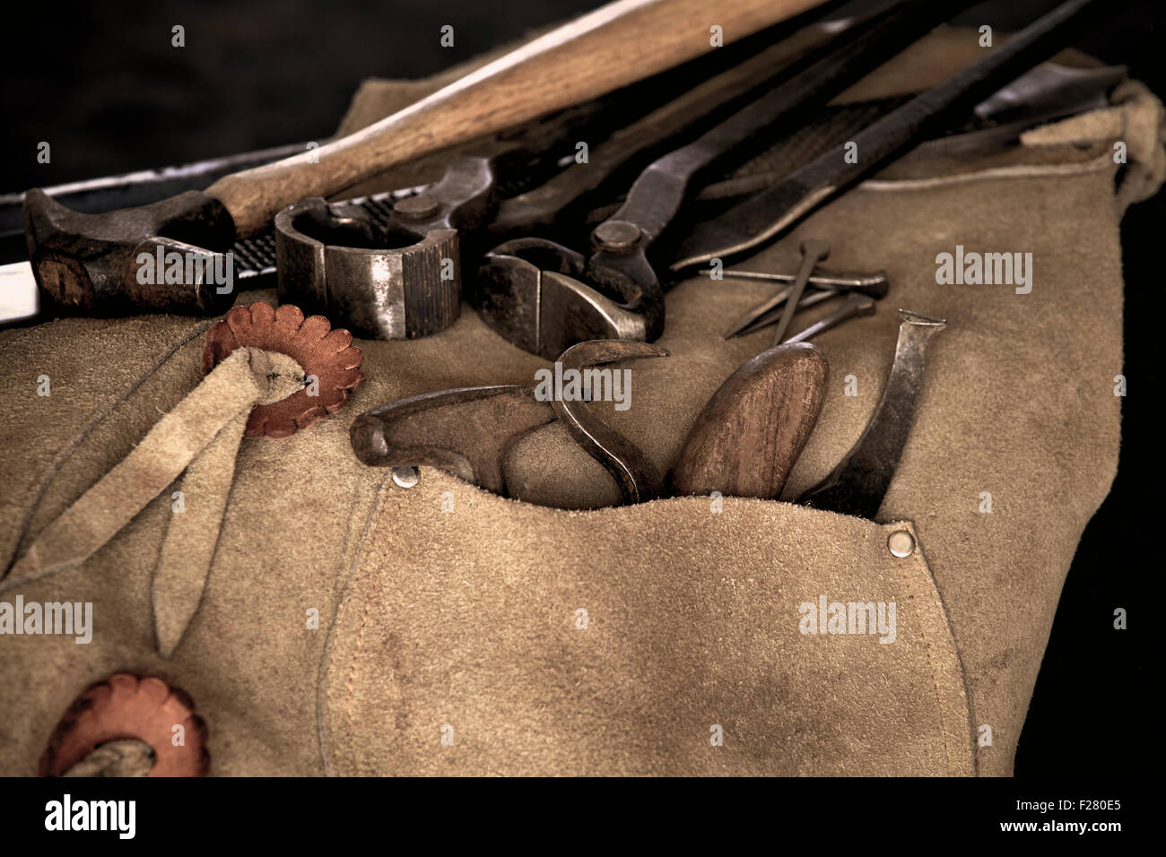 Used Tools of a farrier including rasp, hoof knife, chaps, hoof pick