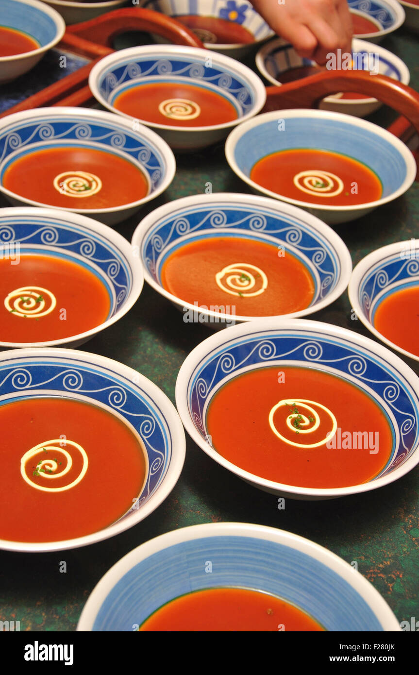 bowls of tomato soup with swirls of cream and a sprig of parsely Stock Photo