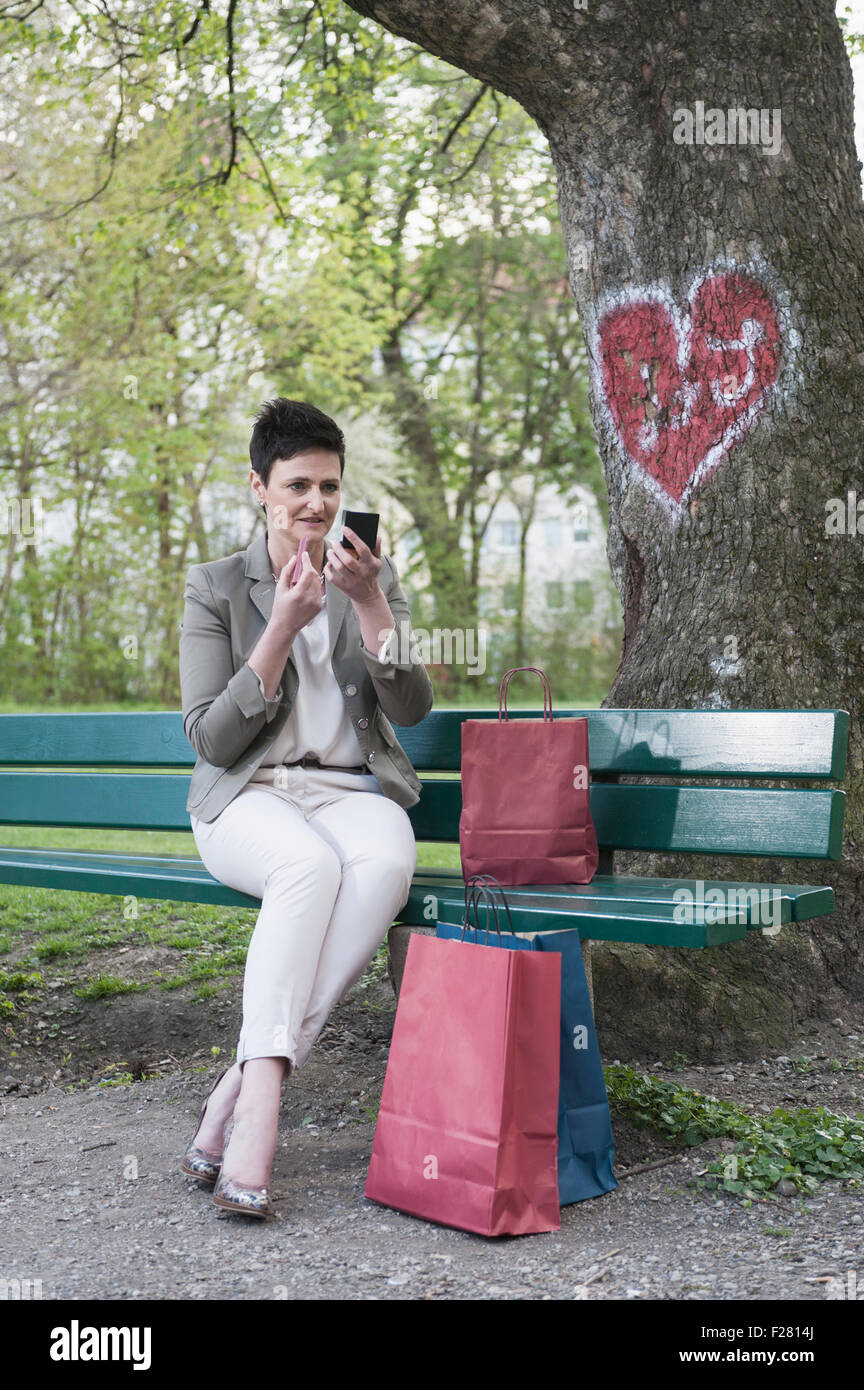 Mature woman on park bench hi-res stock photography and images - Alamy
