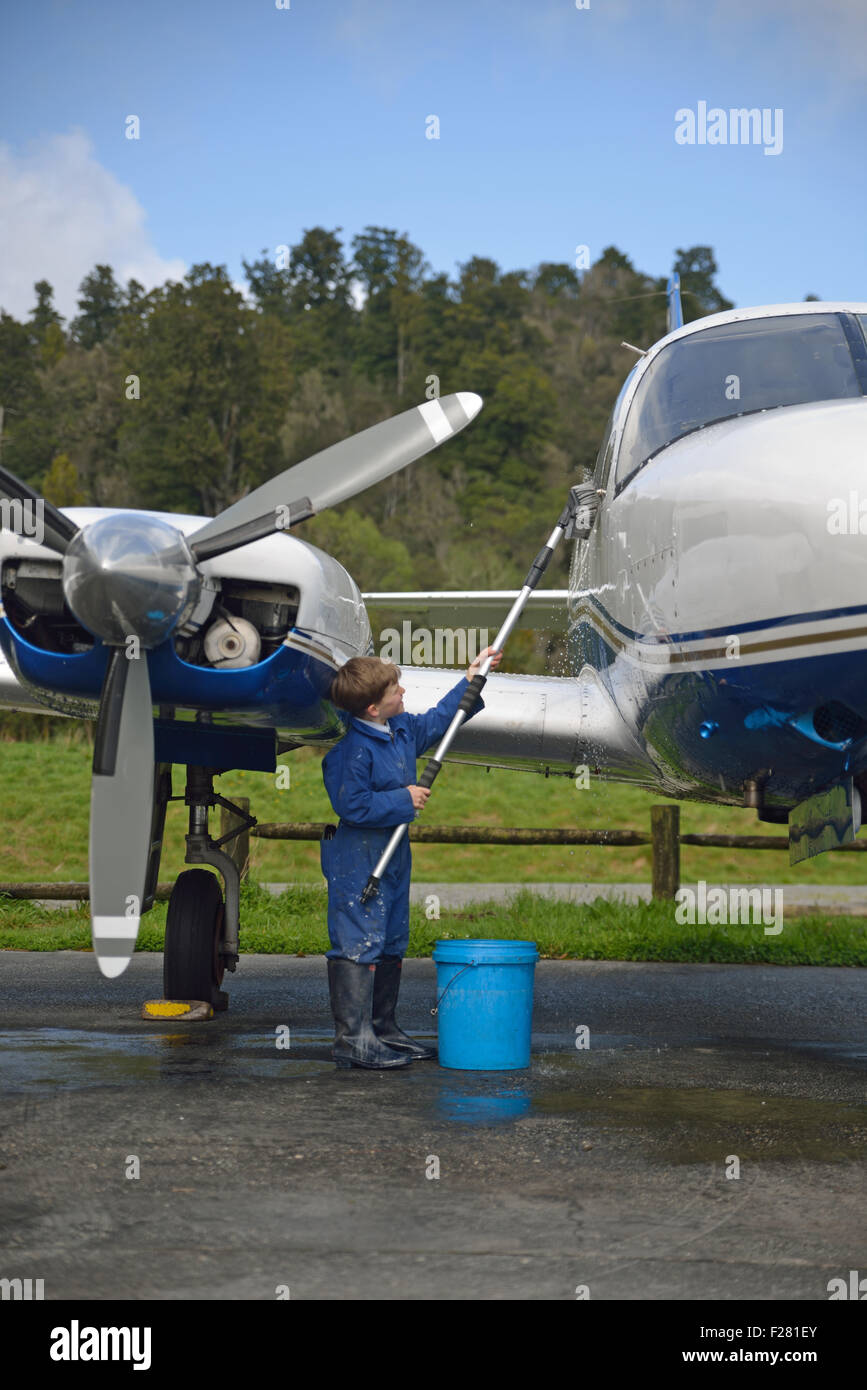 A little boy helps out by washing grandad's aeroplane Stock Photo