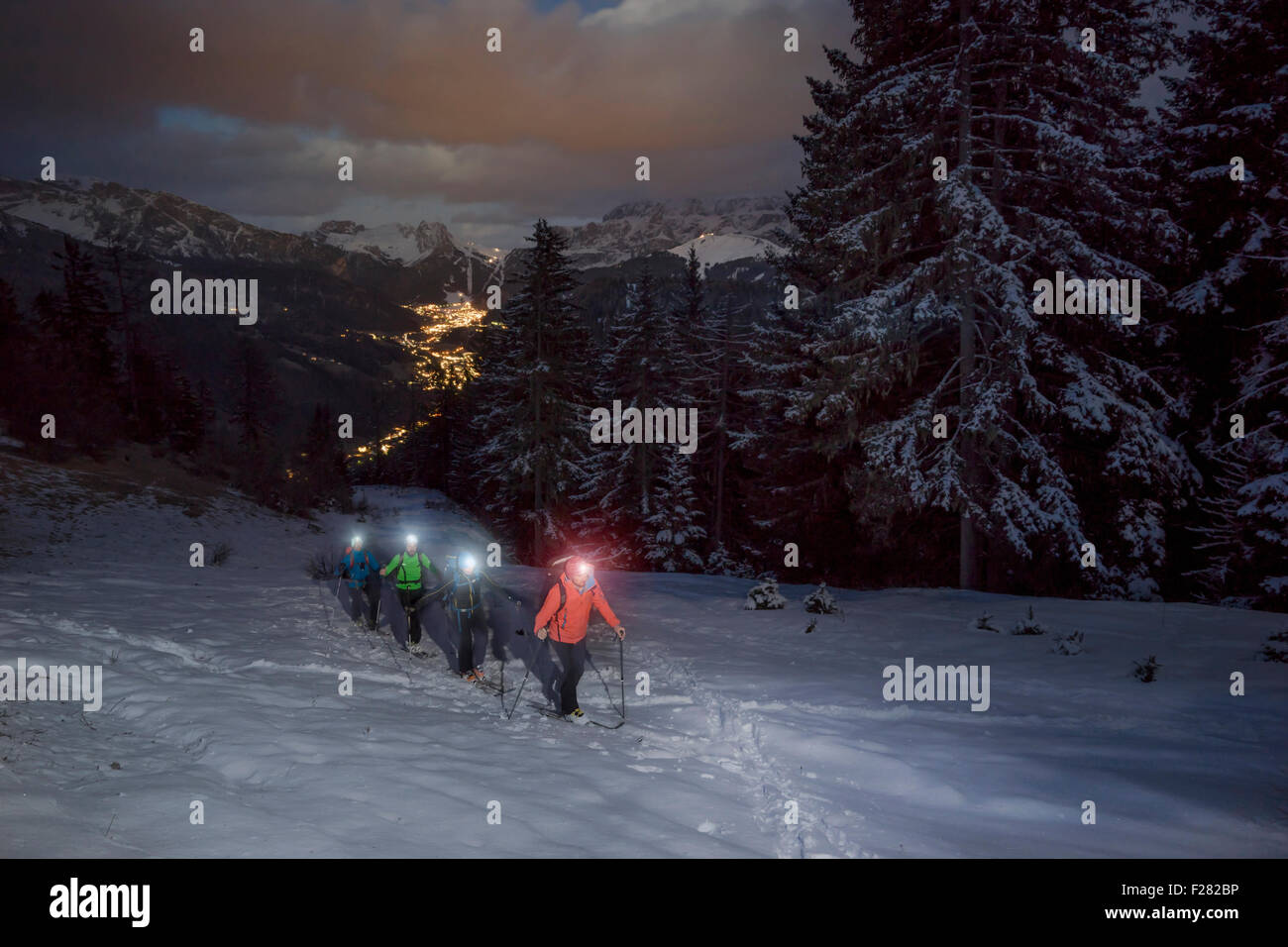 Ski mountaineers climbing on snowy mountain with head torches, Val Gardena, Trentino-Alto Adige, Italy Stock Photo