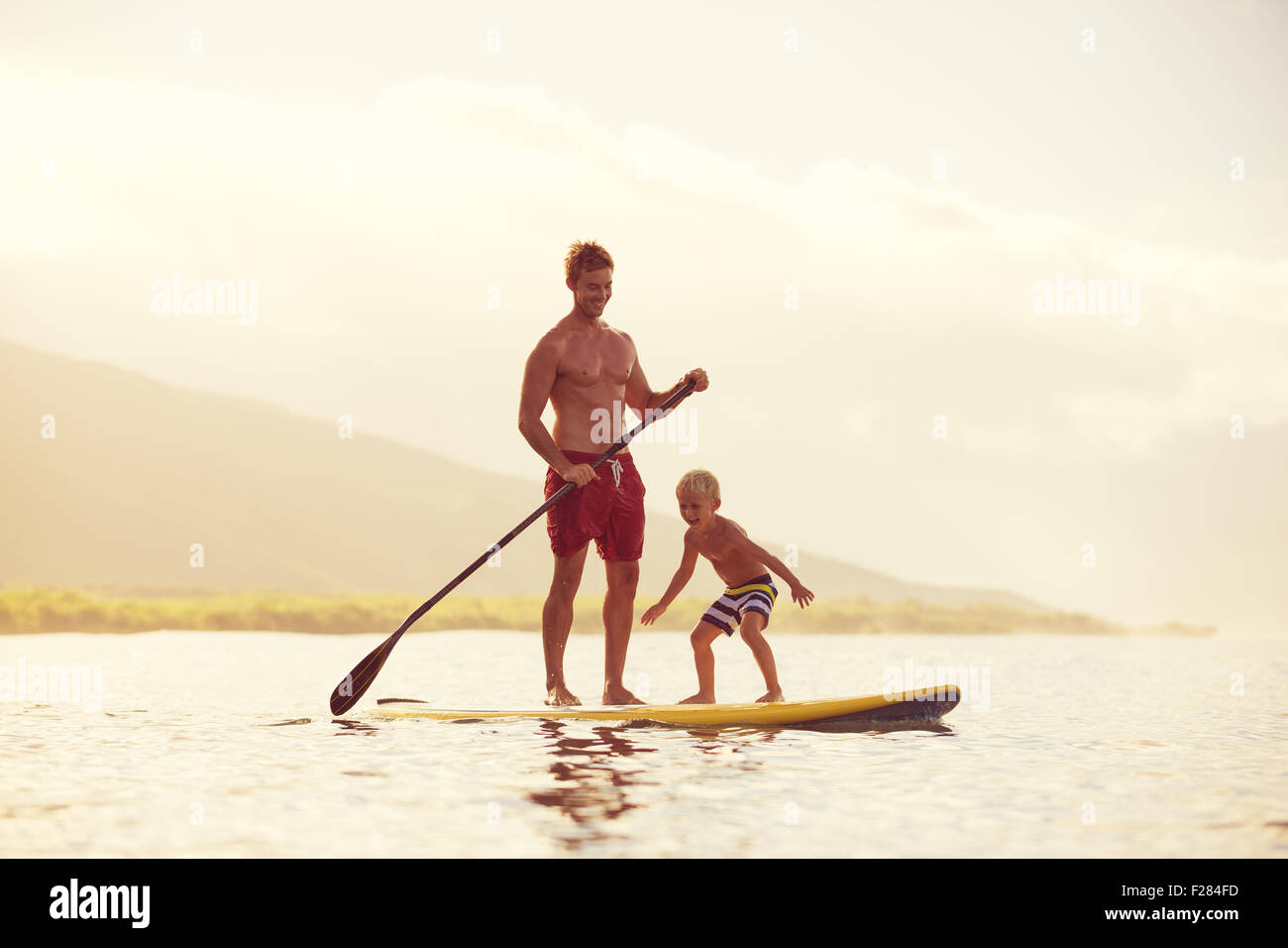 Father and Son Stand Up Paddling at Sunrise Stock Photo Alamy