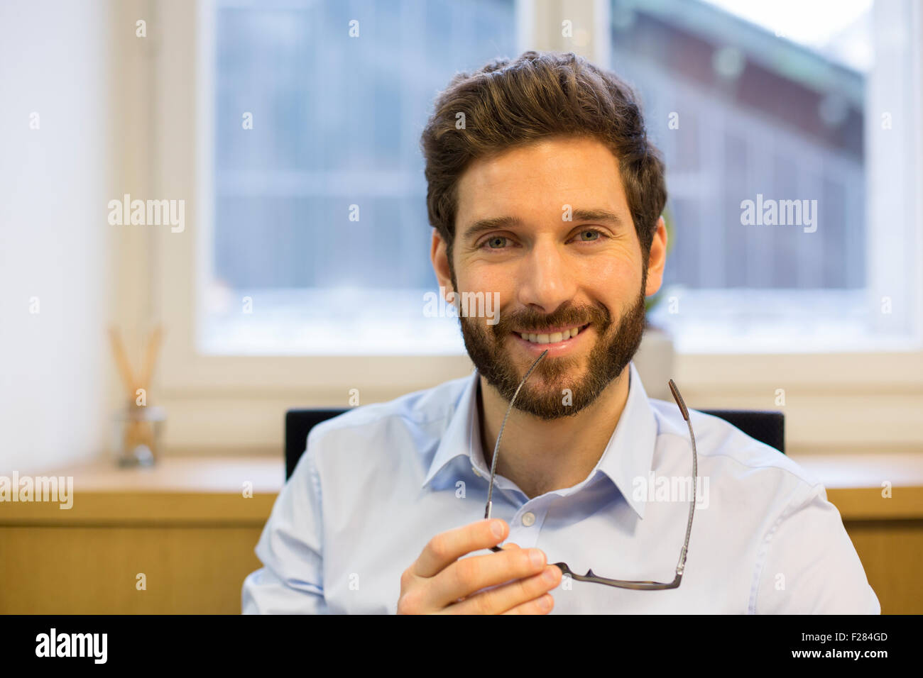 Portrait of man sitting at his desk in office Stock Photo