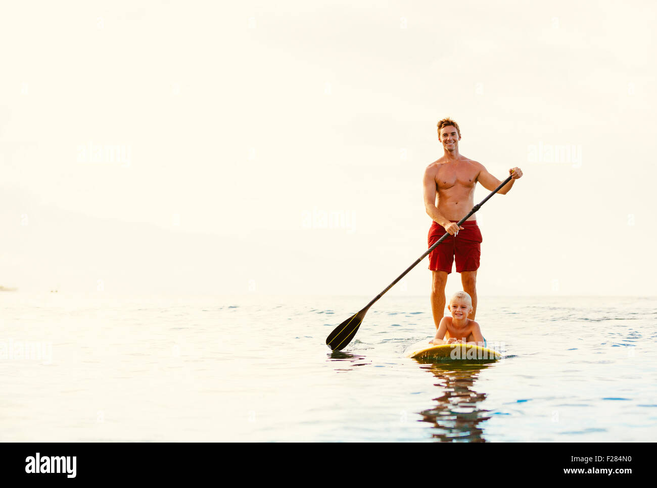 Father and Son Stand Up Paddling at Sunrise Stock Photo Alamy