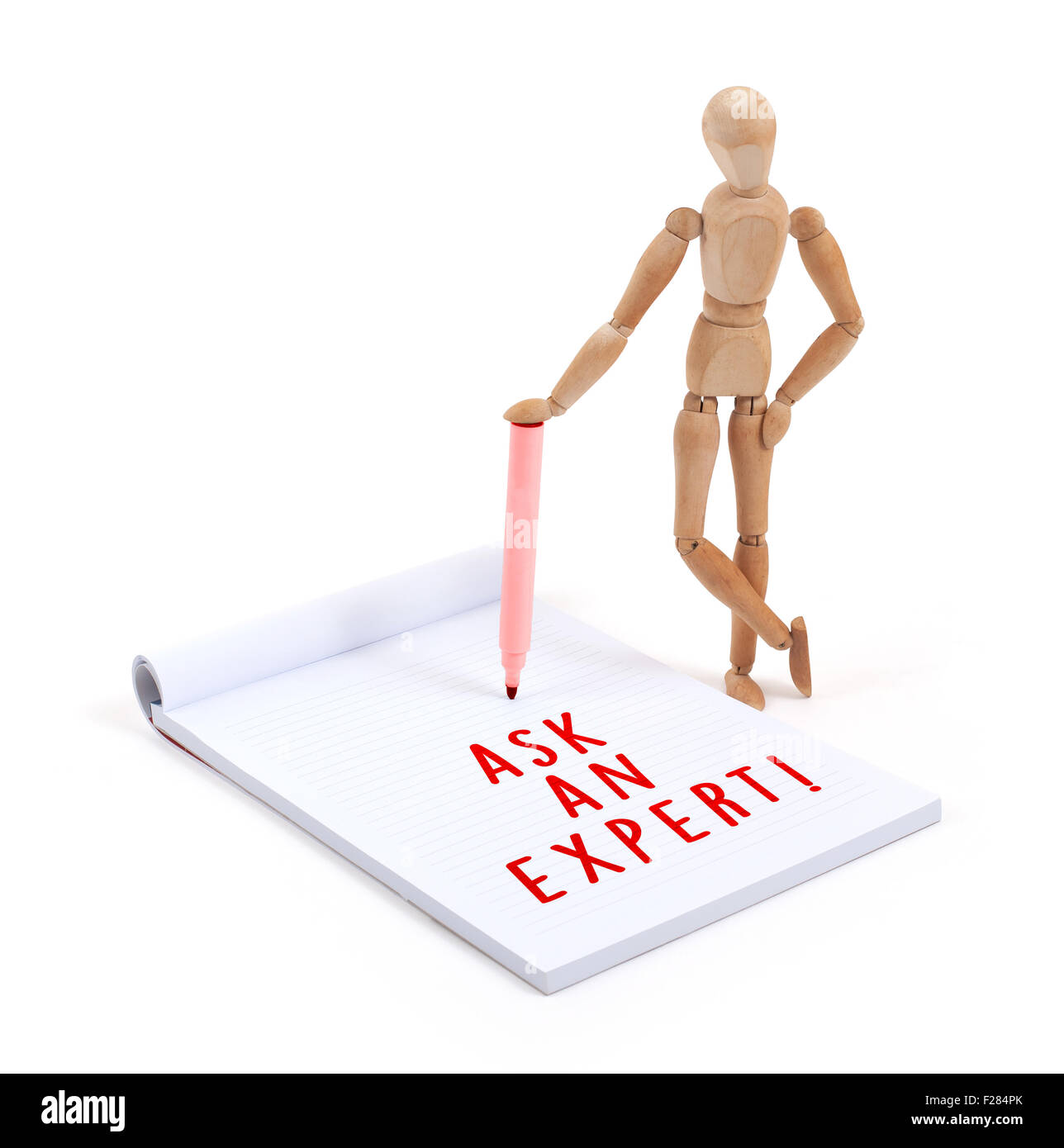 Wooden mannequin writing in a scrapbook - Ask an expert Stock Photo